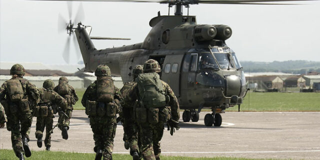 Soldiers running towards a helicopter